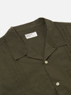 The Olive Tech Cotton S/S Dwight Overshirt is shown from the back as a flat lay against a plain white background. The image highlights the straight hem, short sleeves, and the smooth texture of the olive green cotton fabric.