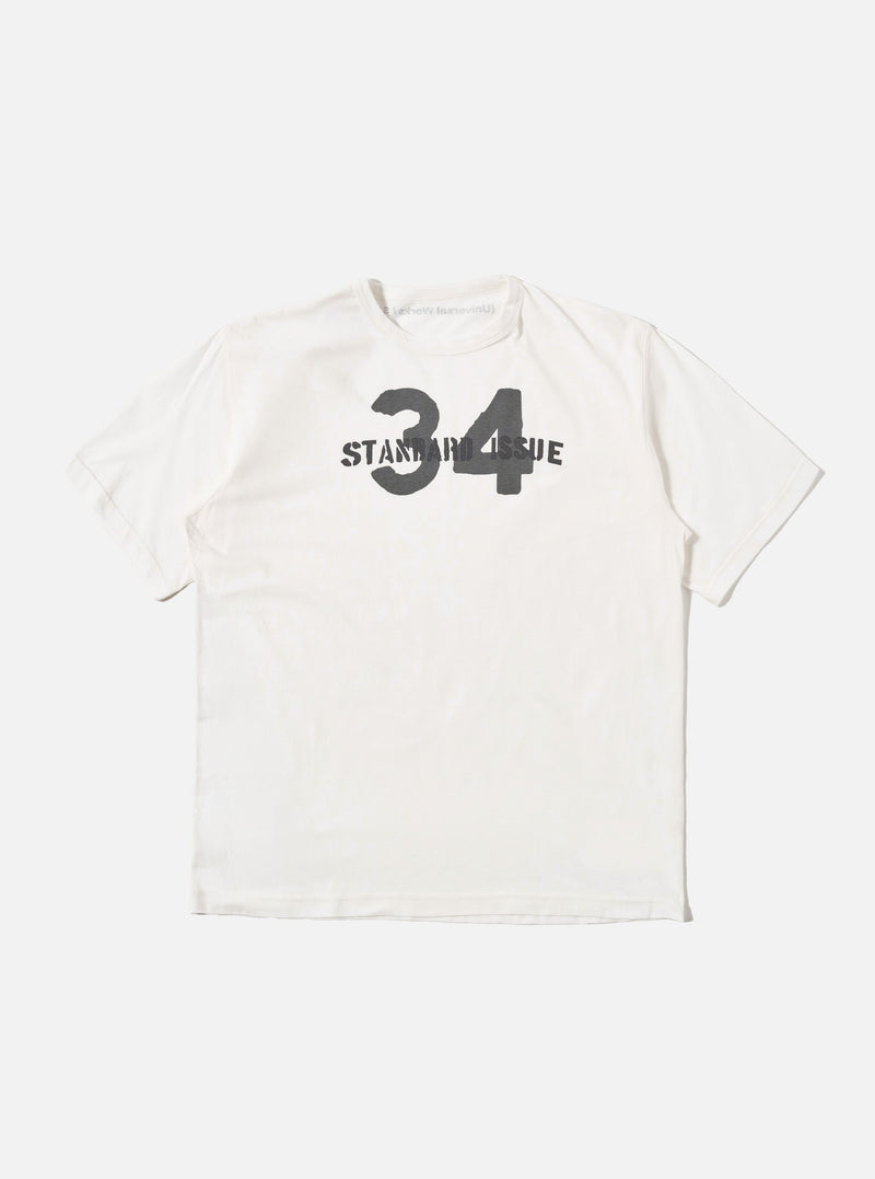 The Ecru Single Jersey 34 Printed Core Tee is shown as a flat lay against a white background. The short-sleeved t-shirt features a ribbed crew neck and a graphic print on the chest. The garment is made from a solid ecru-colored cotton jersey.