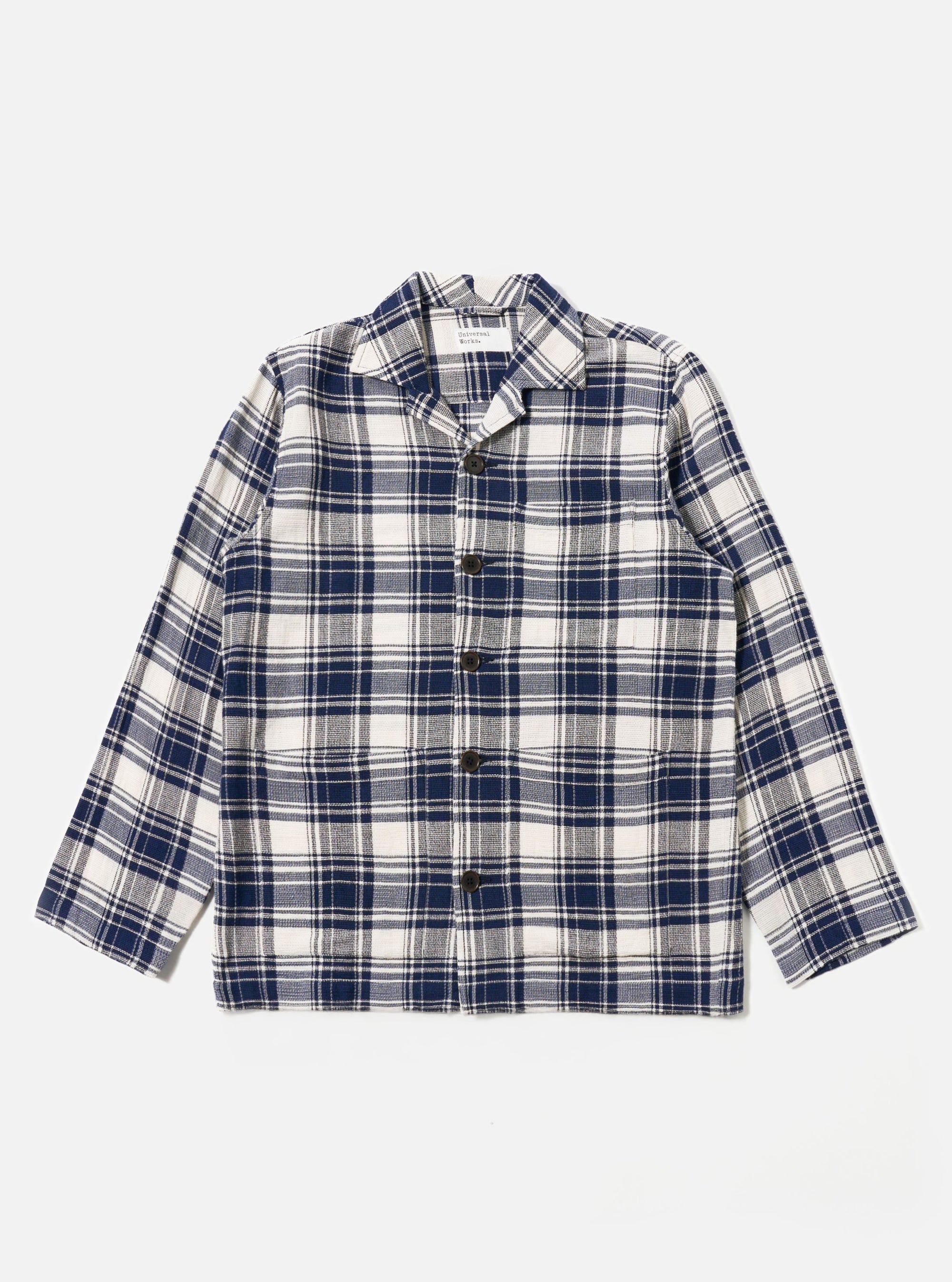 The Navy Texture Plaid Cancun Jacket is shown as a flat lay against a plain white background. The jacket features a structured collar, a central button-down closure, and four large patch pockets on the front. The navy blue cotton fabric has a distinct textured plaid pattern throughout.