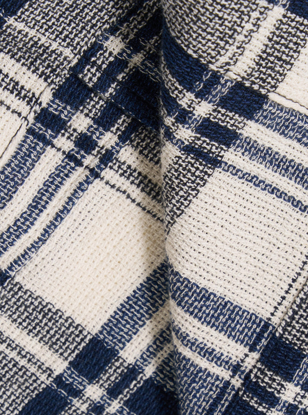 A close-up swatch image of the Navy Texture Plaid Cancun Jacket fabric highlights the intricate navy blue and white plaid pattern. The image focuses on the textured weave of the cotton material, showing the intersecting lines that create the plaid design.
