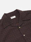 The Brown Diamond Dobby Deck Shirt is shown from the back as a flat lay against a plain white background. The image highlights the shirt's wide fit, the horizontal seam across the upper back, and the side split hem which is longer at the back than the front. The brown cotton fabric features a distinct diamond dobby texture.