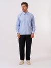 The Blue Mc Stripe Square Pocket Shirt is shown as a flat lay against a white background. The shirt features a fine blue and white vertical stripe pattern, a classic point collar, and a full button-down front. A single, large square patch pocket is prominent on the left chest, and the long sleeves end in adjustable button cuffs. The shirt has a relaxed, loose fit and a curved hem.