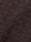 A close-up fabric swatch of the Brown Diamond Dobby Lucky Shirt displays a detailed view of the brown cotton material. The image highlights the intricate, geometric diamond dobby weave and the textured surface of the fabric.