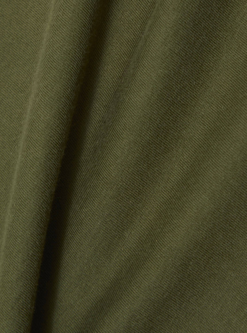 Close-up of the olive single jersey fabric of the A. SOCIETY x Universal Works tee. The soft, textured material is draped to show its quality.