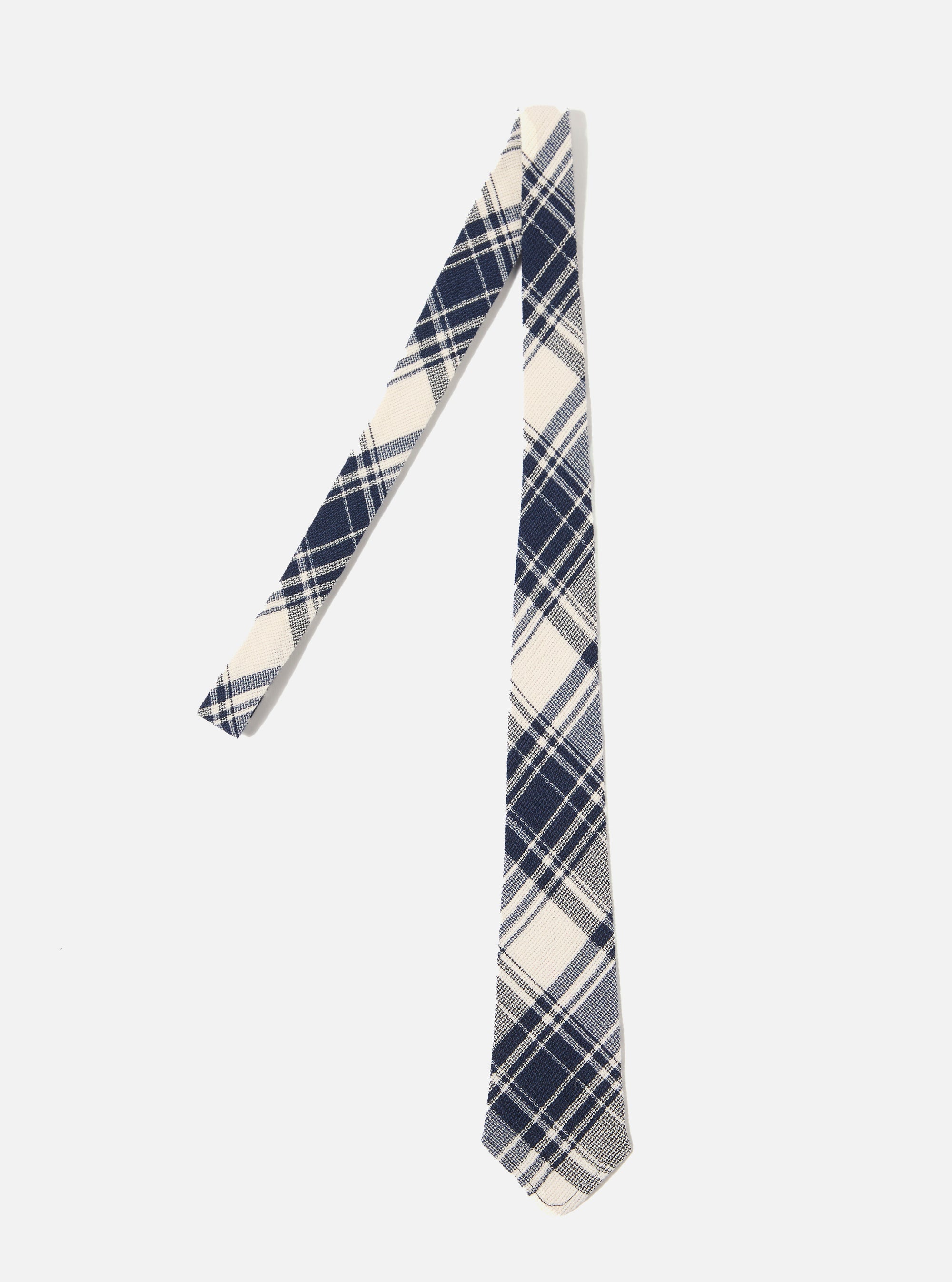 The Navy Texture Plaid Tie is shown as a flat lay against a plain white background. The tie features a bold navy and light blue plaid pattern on a textured, loosely woven cotton gauze fabric. The construction shows a standard pointed tip and a classic necktie shape.