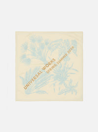 The Cream Cambric Neckerchief is displayed as a flat lay against a plain white background. The square accessory features an exclusive dark-colored graphic print across the cream cotton fabric.