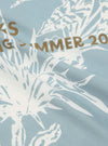 A close-up swatch image of the Pale Blue Cambric Neckerchief fabric. The image focuses on the fine, lightweight cotton cambric material, highlighting its smooth texture and consistent pale blue color. The fabric fills the frame, and no model or mannequin is present.