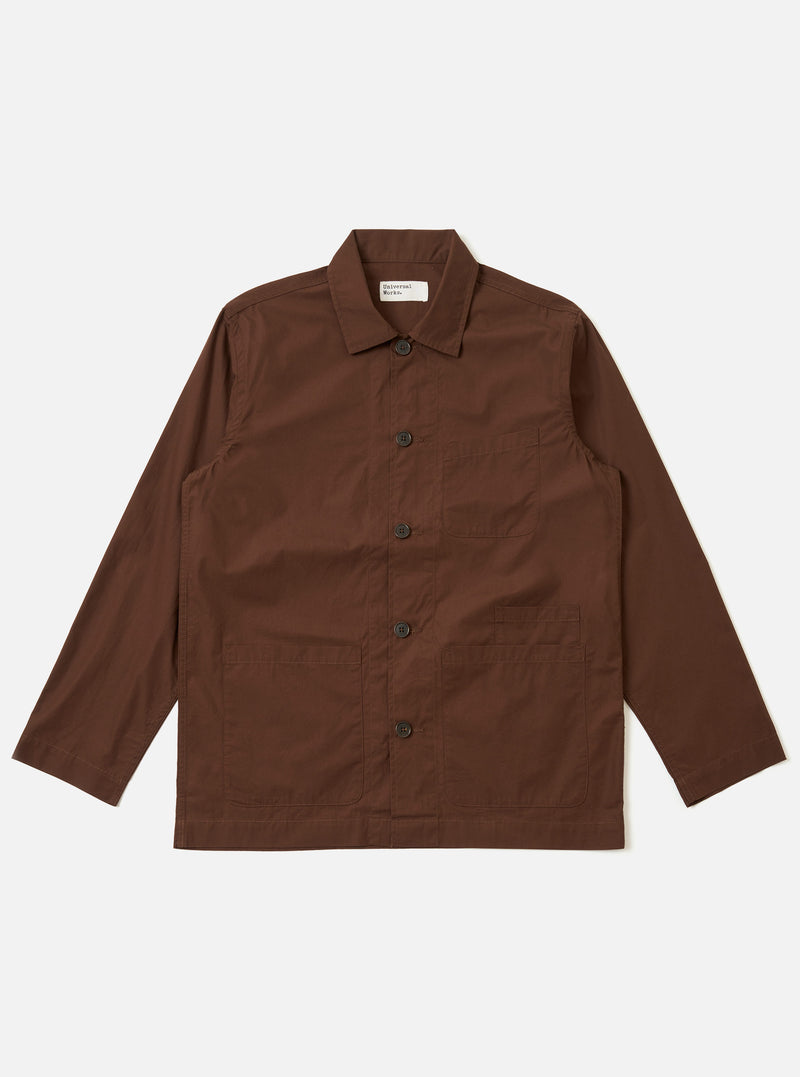 The Brown Peached Poplin Bakers Overshirt is shown as a flat lay against a plain white background. The overshirt features a one-piece collar, a five-button front closure, and a straight hem. It has four front patch pockets: one asymmetric chest pocket, two large lower pockets, and a small coin pocket. The 100% cotton fabric has a soft, matte peached finish in a solid brown color.