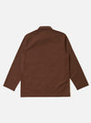 The Brown Peached Poplin Bakers Overshirt is shown from the back as a flat lay against a plain white background. The image highlights the clean construction of the garment's rear panel, featuring a simple straight yoke and a slightly curved hem. The cotton poplin fabric has a smooth, matte brown finish with visible stitching details.