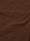 The Brown Peached Poplin Bakers Overshirt is shown from the back as a flat lay against a plain white background. The image highlights the clean construction of the garment's rear panel, featuring a straight hem and a simple, smooth finish on the brown cotton poplin fabric.
