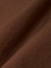 A close-up fabric swatch of the Brown Peached Poplin Bakers Overshirt is shown, highlighting the rich brown color and the smooth, soft texture of the organic cotton poplin fabric.