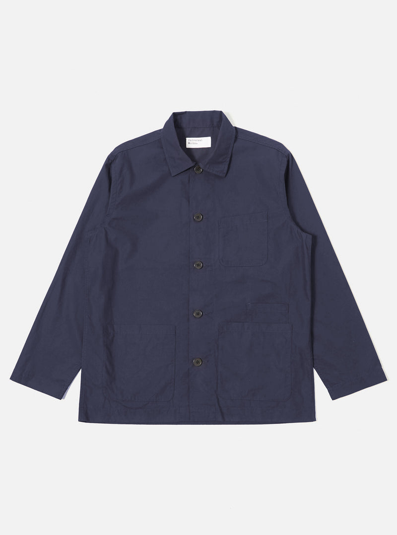 The Navy Peached Poplin Bakers Overshirt is shown as a flat lay against a white background. The overshirt features a classic collar, a central button-down closure, and four front patch pockets: one asymmetric chest pocket and three lower pockets, including a small partially concealed coin pocket. The navy cotton fabric has a soft, matte finish.