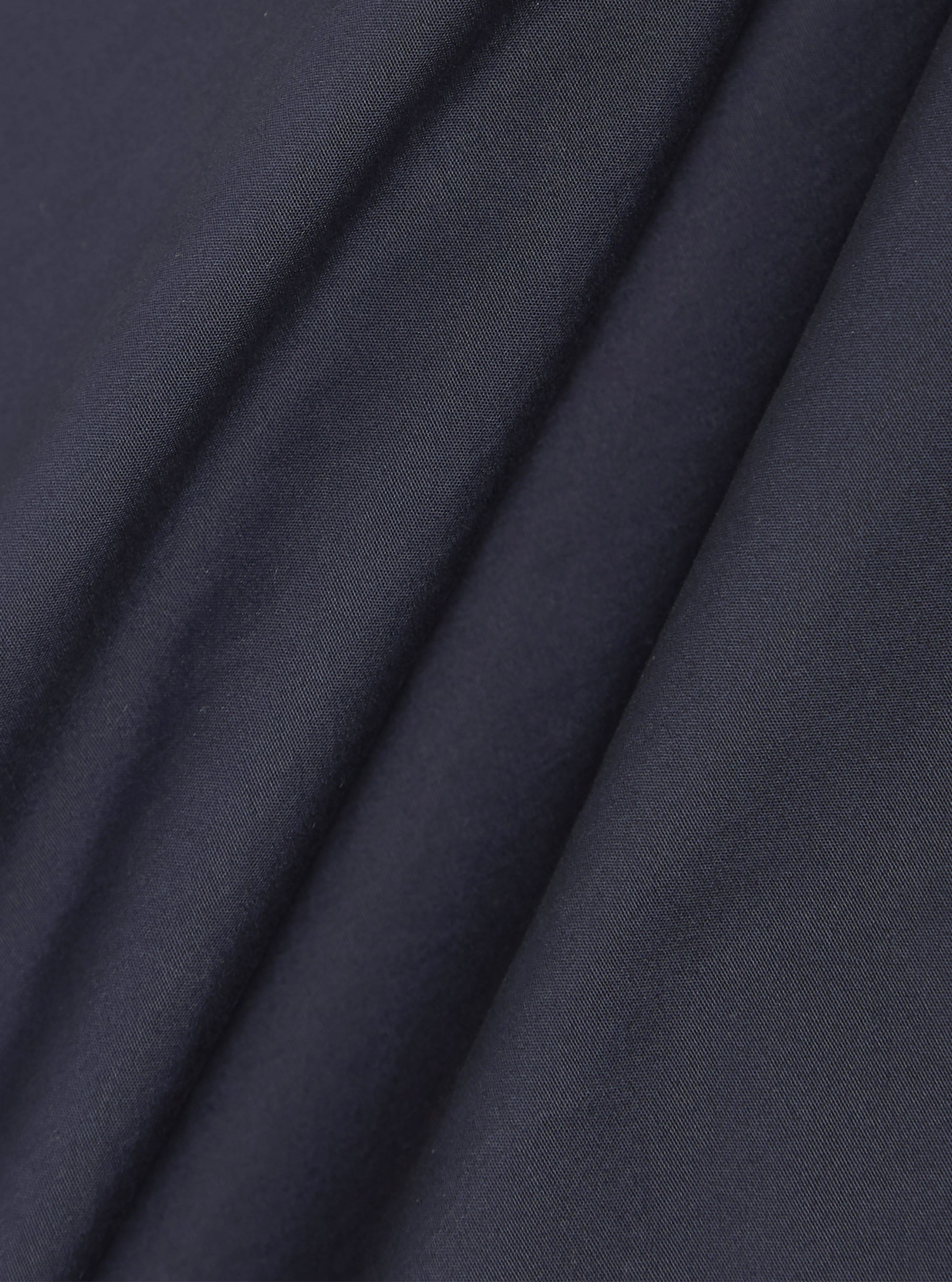 A close-up swatch image of the Navy Peached Poplin Bakers Overshirt fabric. The image focuses on the deep navy blue cotton material, highlighting its smooth, peached finish and fine textile grain.