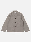 The Grey Brown Wales Glen Check Franck Jacket is shown as a flat lay against a plain white background. The jacket features a classic glen check pattern in shades of grey and brown, a central four-button closure, and three front pockets, including one chest welt pocket and two larger flap pockets at the waist. The garment is constructed with a flat collar and a straight hem.
