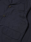 The Navy Peached Poplin Franck Jacket is shown as a flat lay against a white background. The jacket features a short, chore-style cut with a one-piece flat collar, a five-button front closure, and three external pockets including one chest welt pocket and two lower flap pockets. The peached cotton fabric has a smooth, matte finish.
