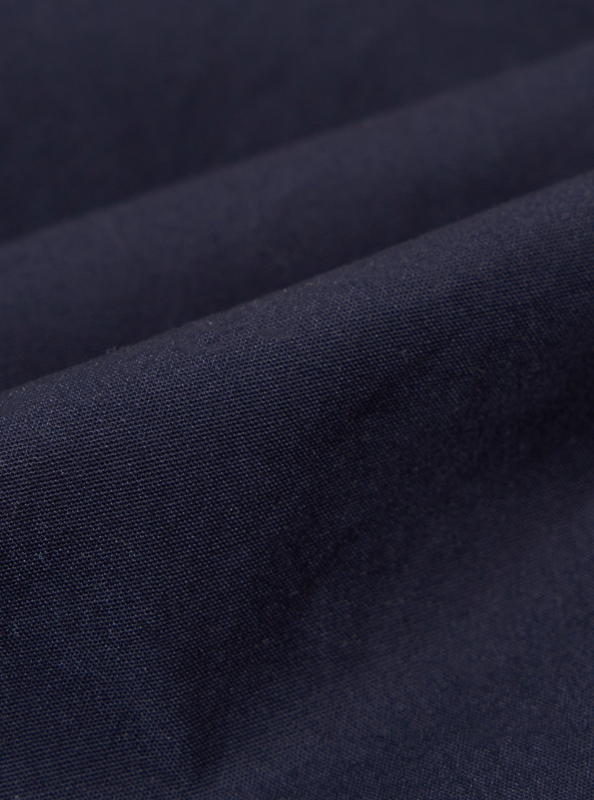 A close-up fabric swatch of the Navy Peached Poplin Franck Jacket shows the fine, smooth texture and deep navy blue color of the cotton poplin material.