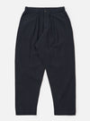 The Dark Navy Ospina Cotton Pleated Track Pant is shown as a flat lay against a plain white background. The trousers feature a single pleat front, an elasticated waistband with a matching drawstring, and a loose fit that tapers toward the hem. The dark navy fabric has a visible seersucker texture.