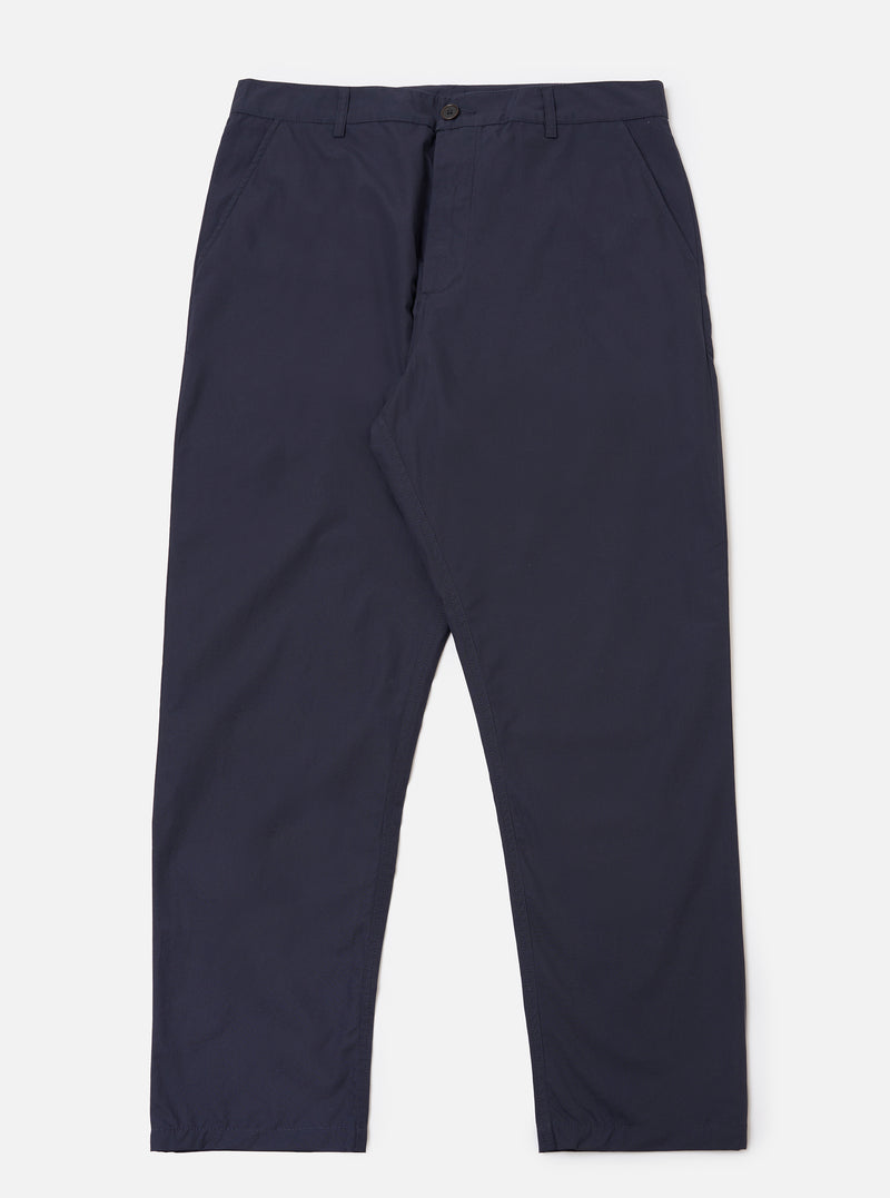The Navy Peached Poplin Military Chino is shown as a flat lay against a plain white background. The trousers feature a mid-rise waistband with belt loops, two side pockets, and a tapered leg. The fabric is a solid navy blue cotton with a smooth, peached texture.
