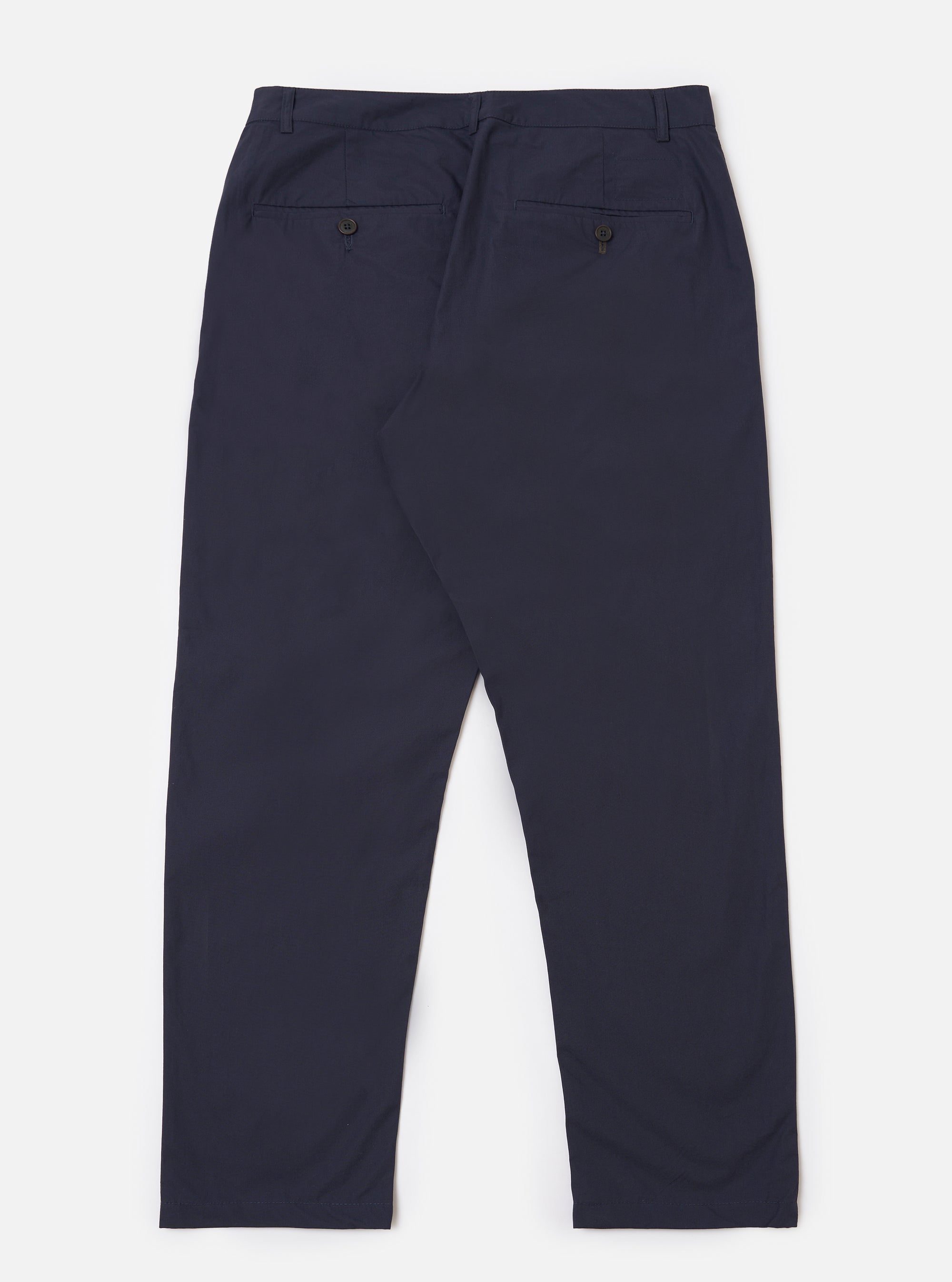 The Navy Peached Poplin Military Chino is shown from the back as a flat lay against a plain white background. The image highlights the two rear jetted buttoned pockets and the waistband with belt loops. The navy blue cotton fabric has a smooth, matte finish.