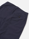 The Navy Peached Poplin Military Chino is shown in a detail view as a flat lay against a plain white background. The image highlights the two rear jetted pockets with button closures and the clean stitching of the back rise. The navy blue cotton fabric has a soft, matte peached finish.