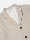 The Brown Kennedy Stripe Three Button Jacket is shown from the back as a flat lay against a plain white background. The jacket features a vertical pinstripe pattern on a brown cotton fabric, highlighting the clean construction of the rear panel, two side vents at the hem, and the simple lines of the sleeves.