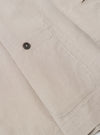The Brown Kennedy Stripe Three Button Jacket is shown in a detail view as a flat lay against a plain white background. The image focuses on the construction of the lower front portion of the jacket, highlighting a large patch pocket and the textured brown cotton fabric with a fine vertical stripe pattern.