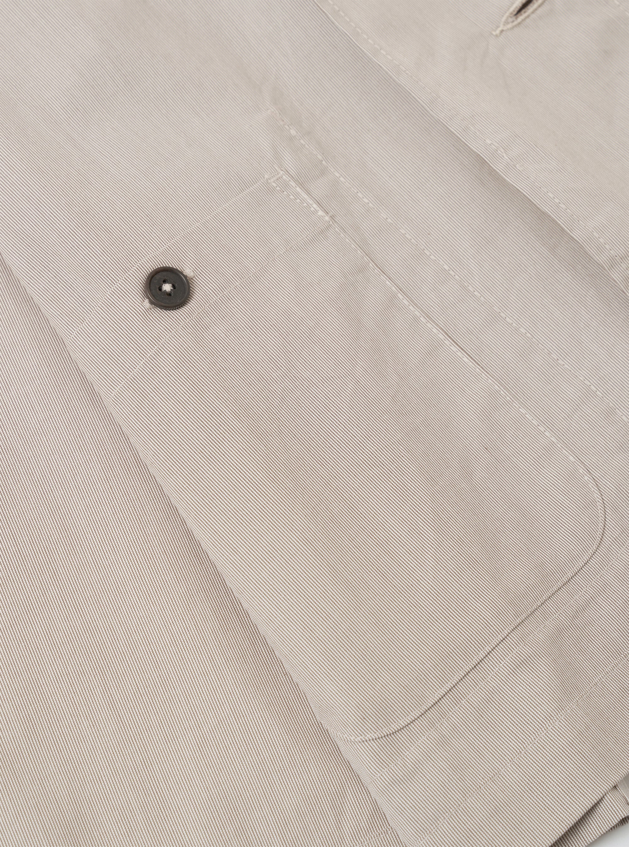 The Brown Kennedy Stripe Three Button Jacket is shown in a detail view as a flat lay against a plain white background. The image focuses on the construction of the lower front portion of the jacket, highlighting a large patch pocket and the textured brown cotton fabric with a fine vertical stripe pattern.
