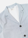 The Navy Kennedy Stripe Three Button Jacket is shown from the back as a flat lay against a plain white background. The jacket features a vertical pinstripe pattern, a central rear vent, and structured shoulders. The navy cotton fabric has a crisp, tailored appearance.