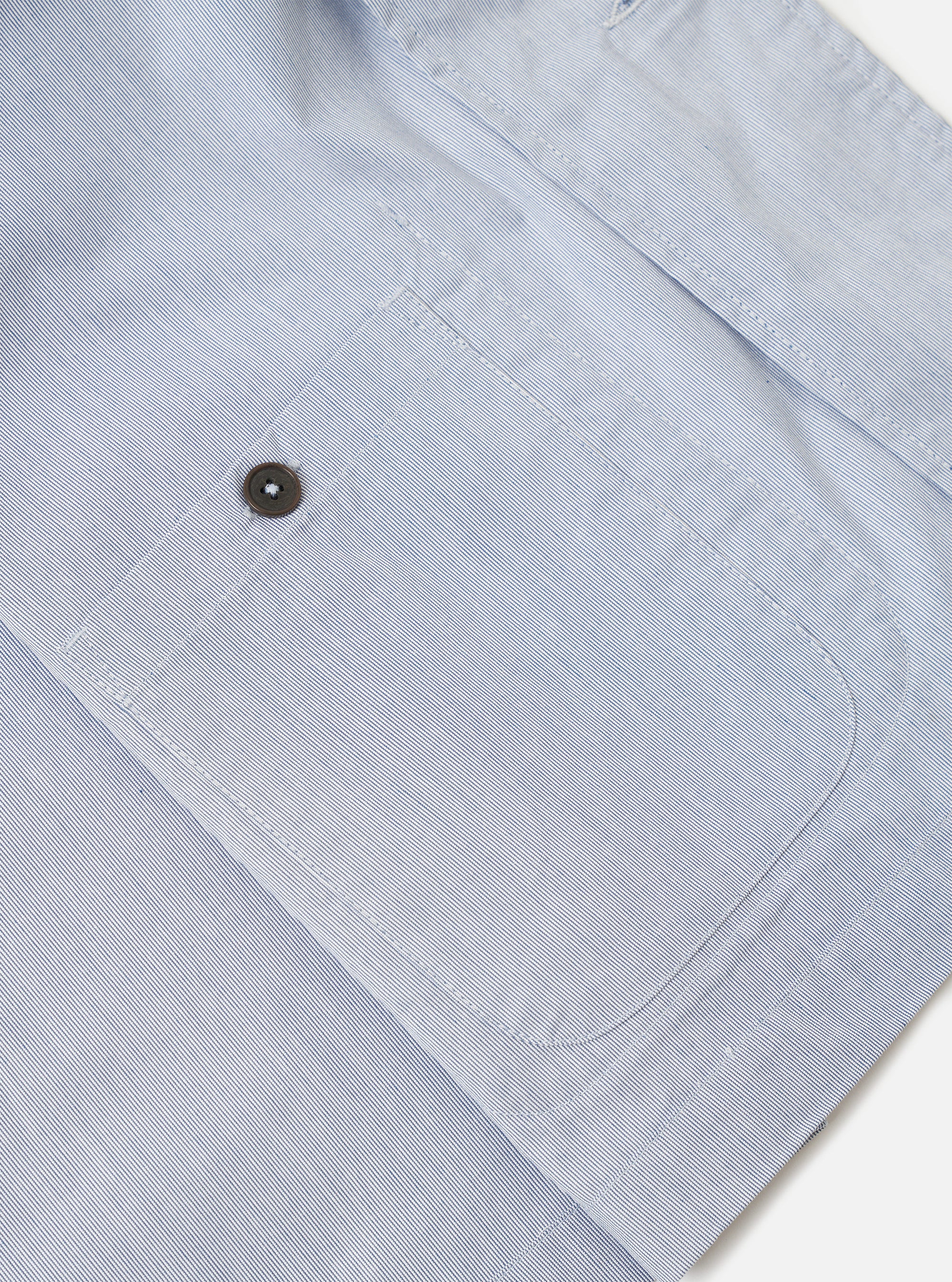 The Navy Kennedy Stripe Three Button Jacket is shown in a detail view as a flat lay against a plain white background. The image focuses on the interior construction of the jacket, highlighting the unlined back, clean internal seams, and a single chest pocket. The navy blue cotton fabric features a subtle vertical Kennedy stripe pattern throughout.