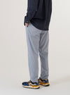 A model wears the Navy Kennedy Stripe Military Chino, shown from the waist down against a plain white background. The trousers feature a vertical navy and white stripe pattern, a button fly, and two front slanted pockets. The model is wearing the chinos with a light-colored shirt and black shoes, highlighting the slim, tapered fit of the garment.