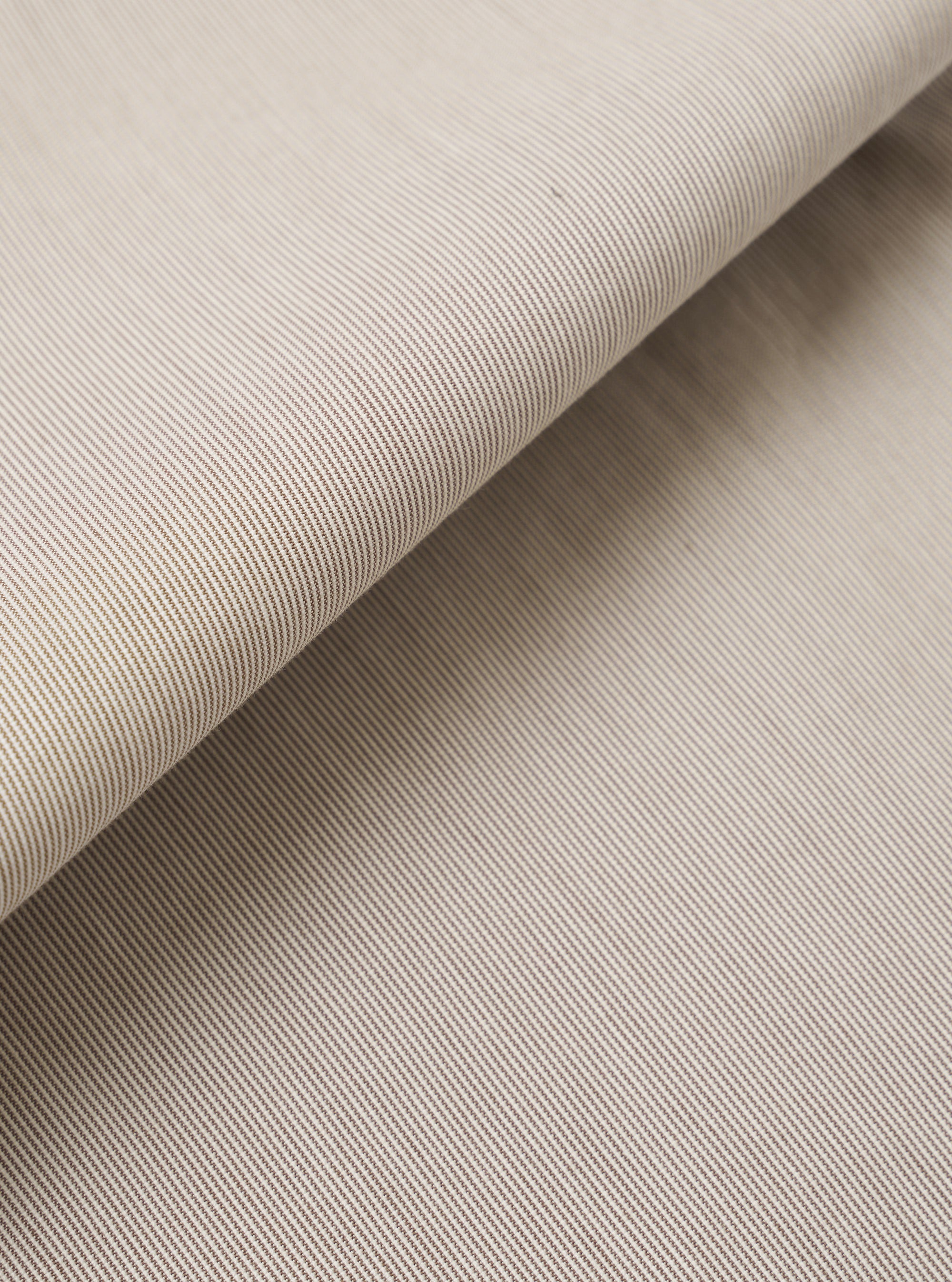 A close-up fabric swatch of the Brown Kennedy Stripe Military Chino highlights the brown color and fine vertical stripe pattern of the cotton fabric. The material features a distinct weave, and the swatch fills the entire frame.