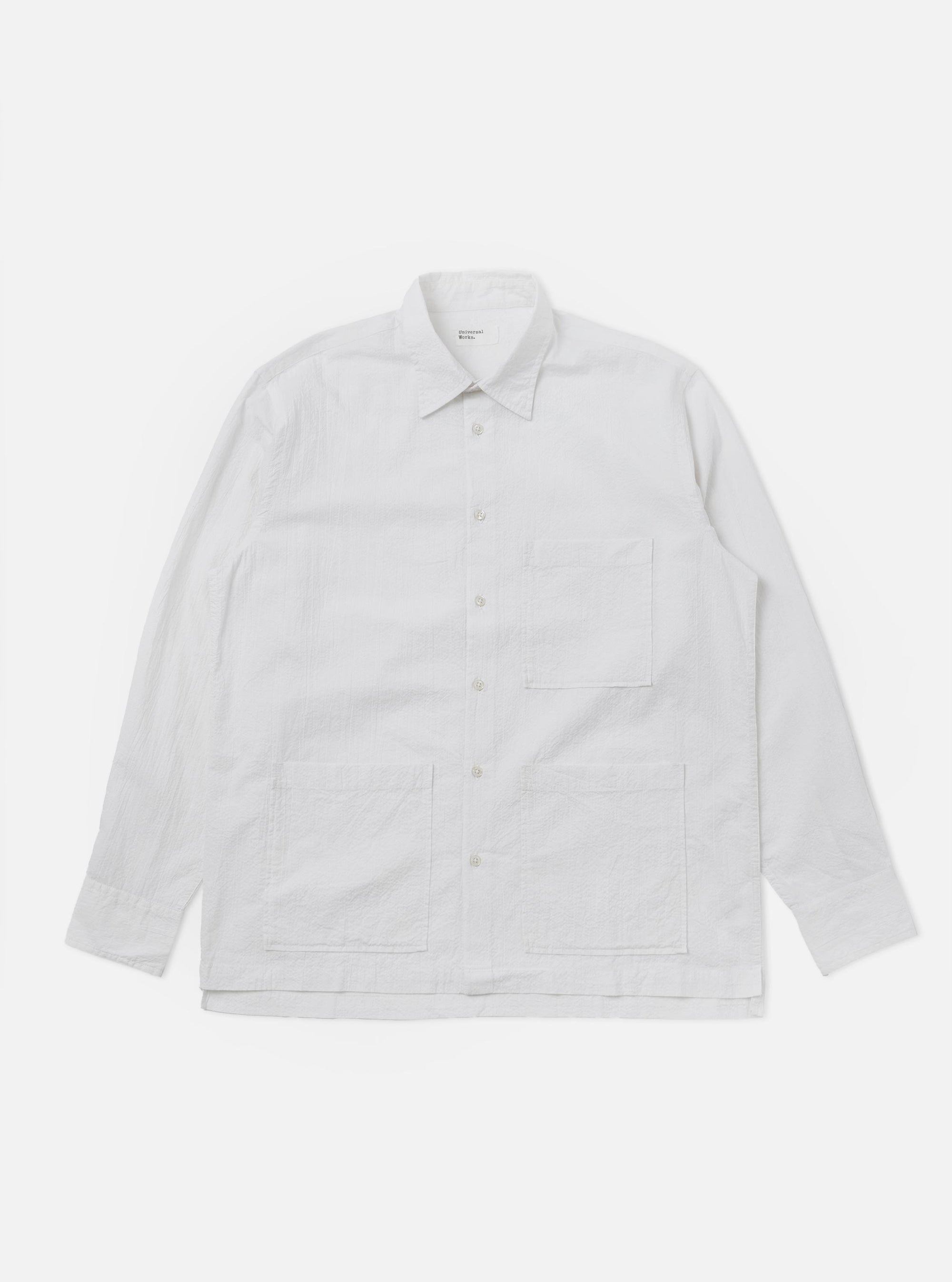 The White Seersucker Double Lucky Shirt is shown as a flat lay against a white background. The shirt features a classic button-down collar, a full-length button placket, and a single chest pocket. The fabric is made of a lightweight white cotton with a distinctive puckered seersucker texture.