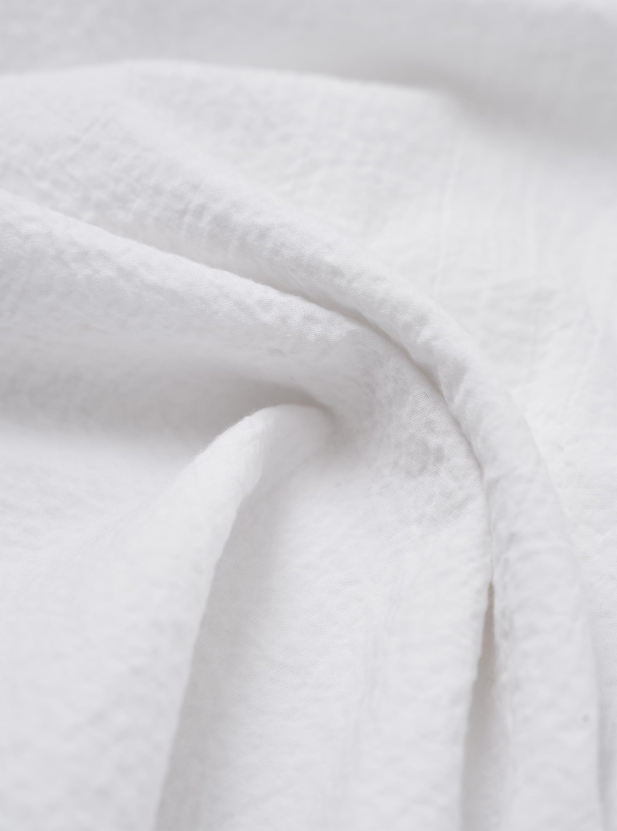 A close-up fabric swatch of the White Seersucker Double Lucky Shirt, showing the characteristic puckered and wrinkled texture of the white cotton seersucker material. No model or mannequin is present.
