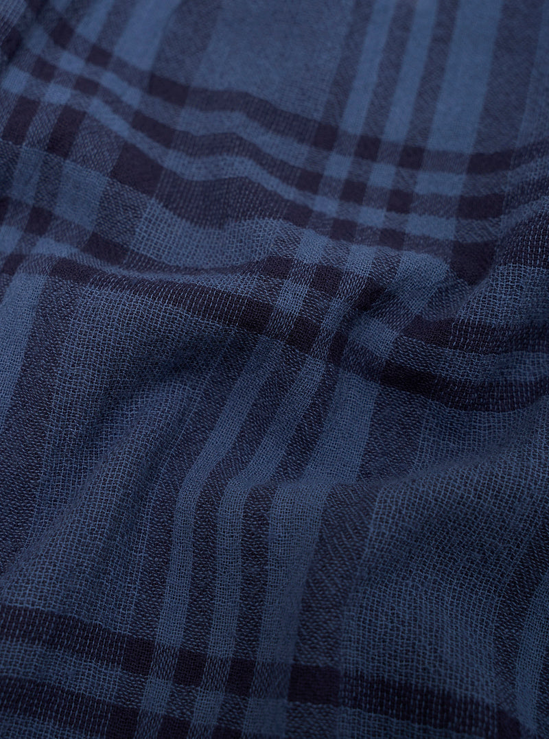 Close-up of blue plaid fabric with a focus on texture and pattern.