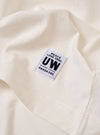 The Antique White Recycled/Bio Jersey Henry L/S Tee is shown from a rear angle as a flat lay against a plain white background. The image highlights the simple, clean construction of the back of the garment, featuring a straight hem and long sleeves. The fabric is a solid antique white jersey.