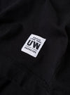 The Black Recycled/Bio Jersey Henry L/S Tee is shown from the back as a flat lay against a plain white background. The image highlights the clean construction of the shoulders and the straight hem of the long-sleeved garment. The black jersey fabric appears smooth and consistent throughout.