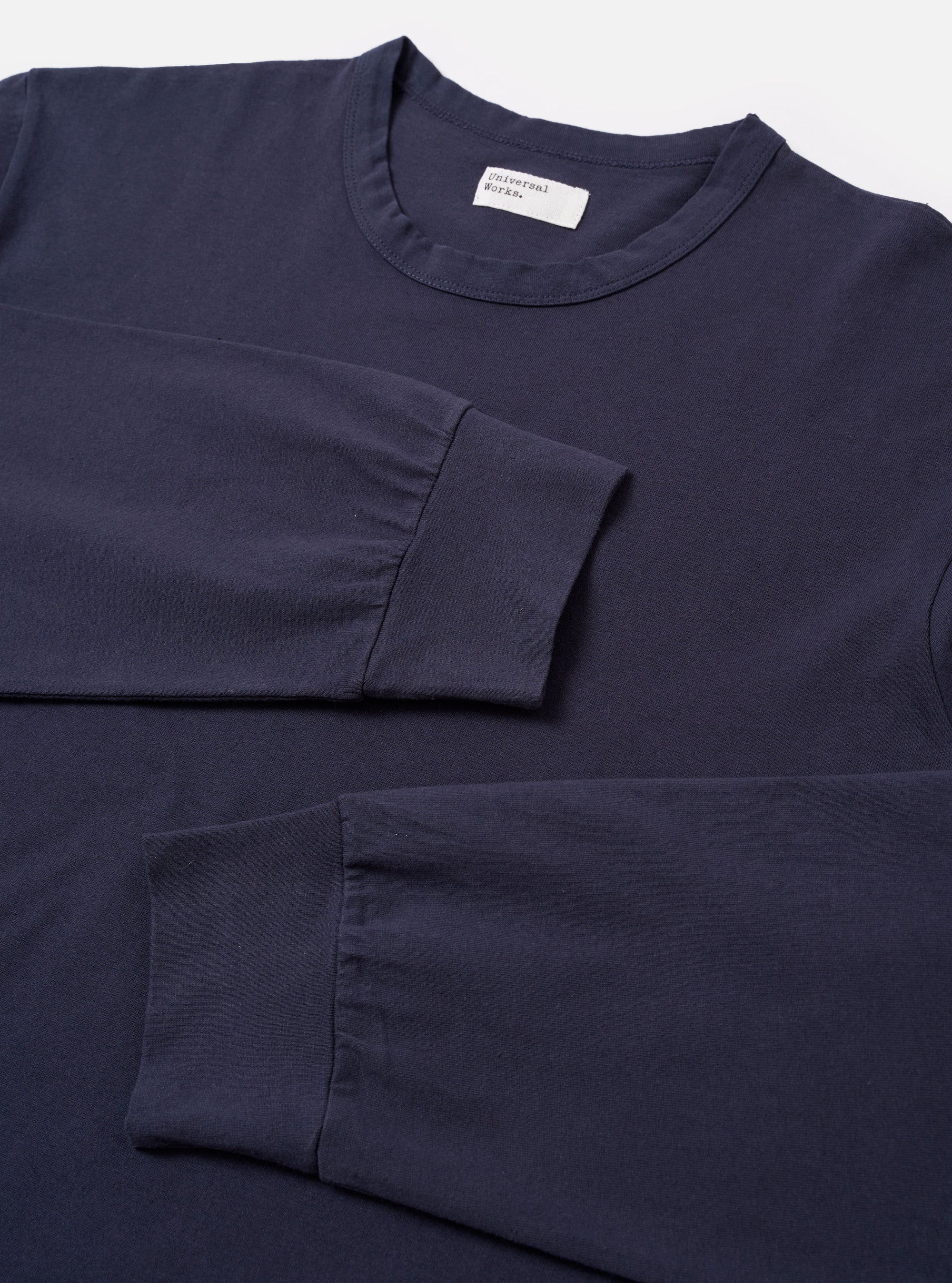 The Navy Recycled/Bio Jersey Henry L/S Tee is shown from the back as a flat lay against a plain white background. The image highlights the smooth texture of the dark navy jersey fabric and the clean construction of the garment's rear, featuring long sleeves and a ribbed crew neckline.