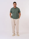 The Green Argyll Jersey Newlyn Polo is shown as a flat lay against a white background. The polo features a tonal green Argyll diamond pattern across the body, a classic collar, and a three-button placket.