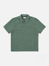 The Green Argyll Jersey Newlyn Polo is shown as a flat lay against a white background. The polo features a two-button placket, a one-piece collar, and a large patch pocket on the left chest. The fabric has a distinct green and white Argyll diamond pattern throughout.
