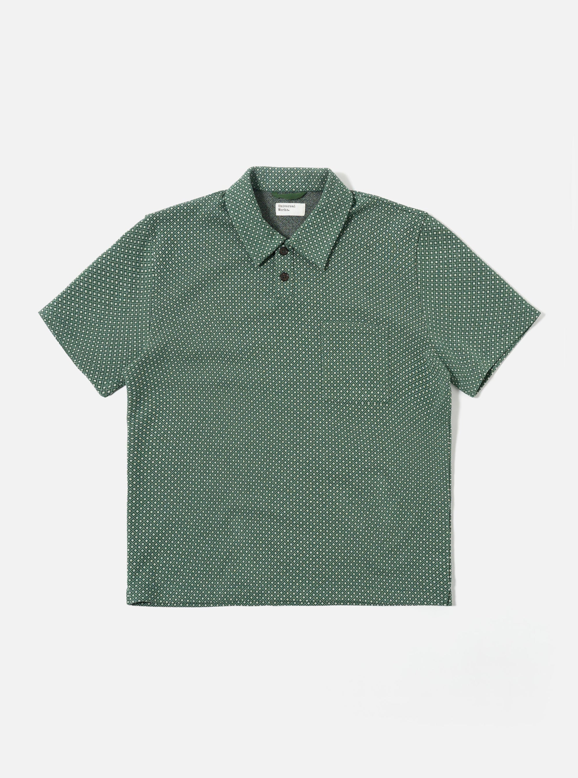 The Green Argyll Jersey Newlyn Polo is shown as a flat lay against a white background. The polo features a two-button placket, a one-piece collar, and a large patch pocket on the left chest. The fabric has a distinct green and white Argyll diamond pattern throughout.