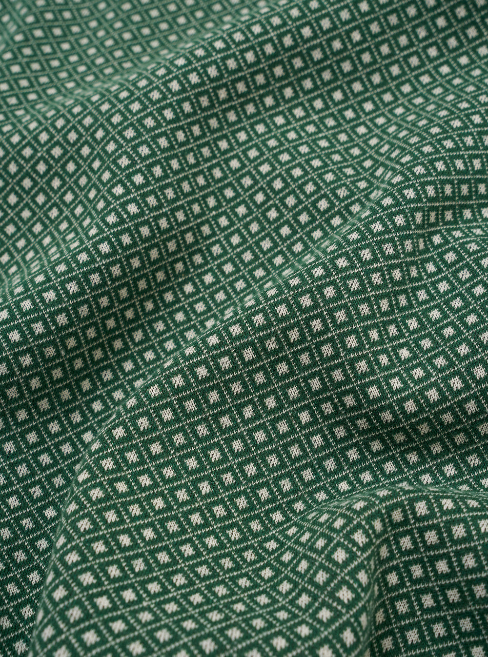 The Green Argyll Jersey Sleeveless Crew is shown from the back as a flat lay against a plain white background. The image highlights the garment's sleeveless design, ribbed crew neckline, and straight hem. The fabric features a prominent green argyll diamond pattern.