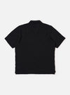The Black Fantasy Checkerboard Vacation Polo is shown from the back as a flat lay against a plain white background. The image highlights the all-over black and grey checkerboard pattern, the structured one-piece collar, and a straight hem with small side vents.