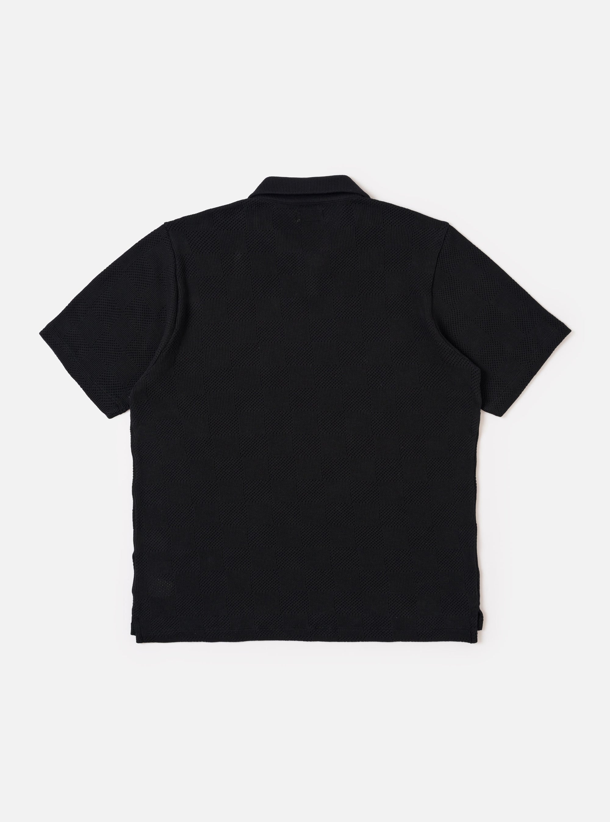 The Black Fantasy Checkerboard Vacation Polo is shown from the back as a flat lay against a plain white background. The image highlights the all-over black and grey checkerboard pattern, the structured one-piece collar, and a straight hem with small side vents.