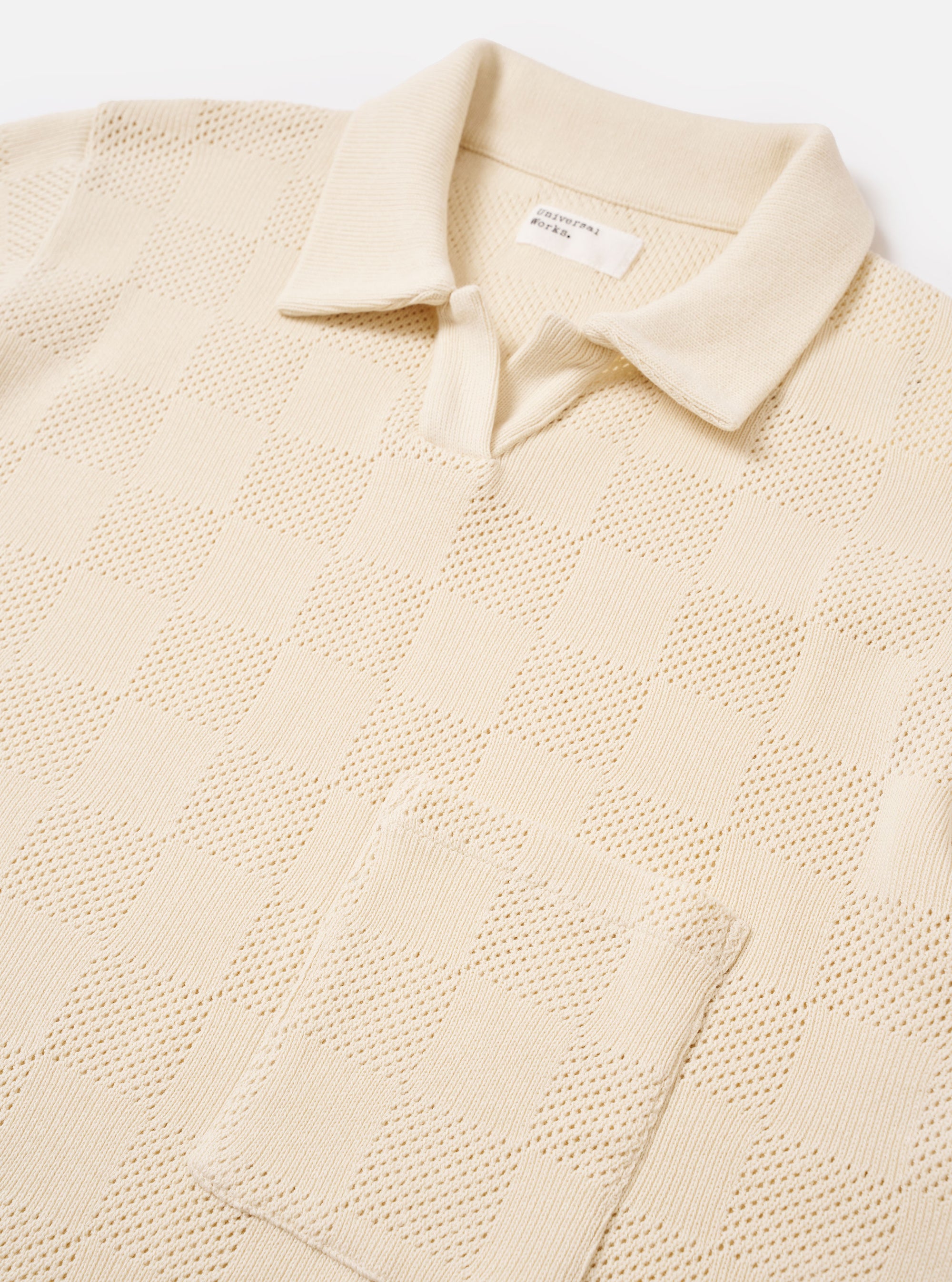 The Ecru Fantasy Checkerboard Vacation Polo is shown as a flat lay against a plain white background. The polo features a classic collar, a central button-down front, and short sleeves. The fabric is highlighted by an all-over textured checkerboard knit in a solid ecru color.