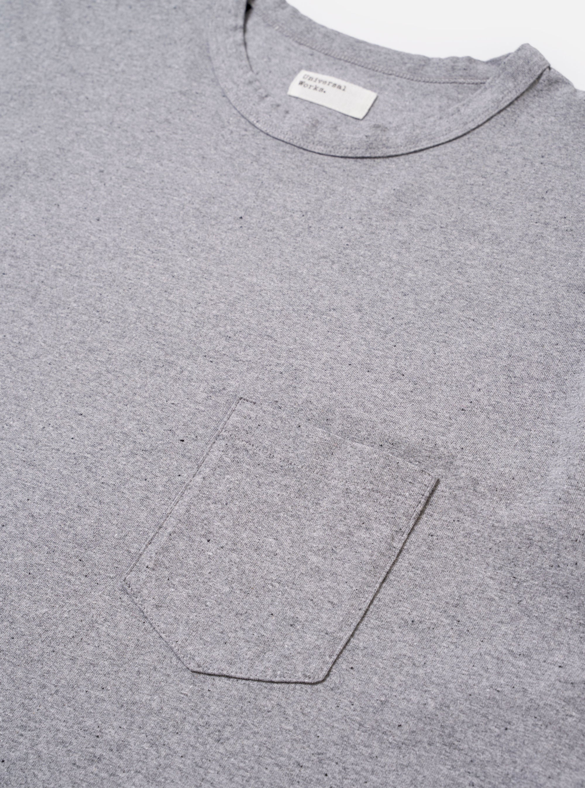 The Grey Marl Recycled/Bio Jersey Core Pocket Tee is shown from the back as a flat lay against a plain white background. The image highlights the clean construction and the soft, heathered texture of the grey marl jersey fabric. The T-shirt features a classic crew neckline, short sleeves, and a straight hem.