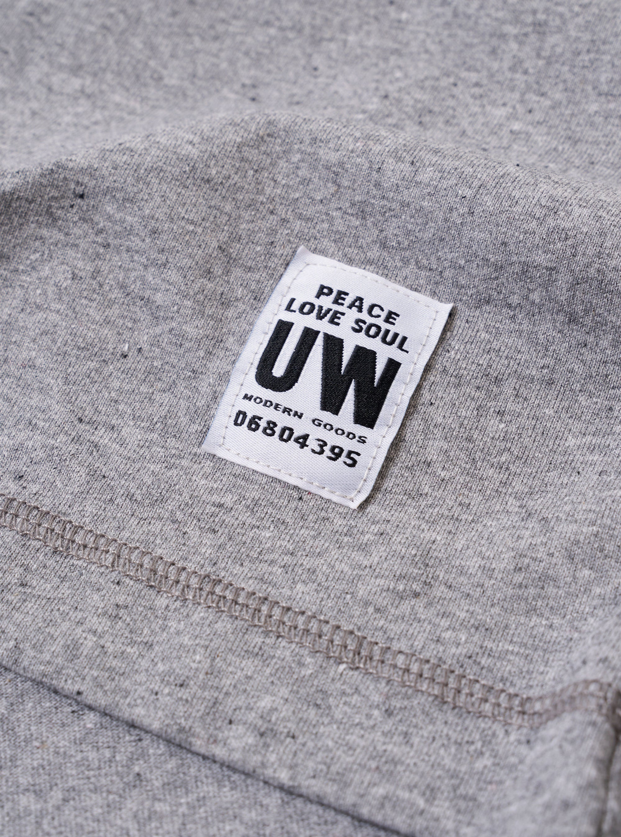 The Grey Marl Recycled/Bio Jersey Core Pocket Tee is shown from a rear angle as a flat lay against a plain white background. The image highlights the clean construction of the t-shirt's back, featuring a straight hem and short sleeves. The fabric has a soft, grey marl jersey texture.