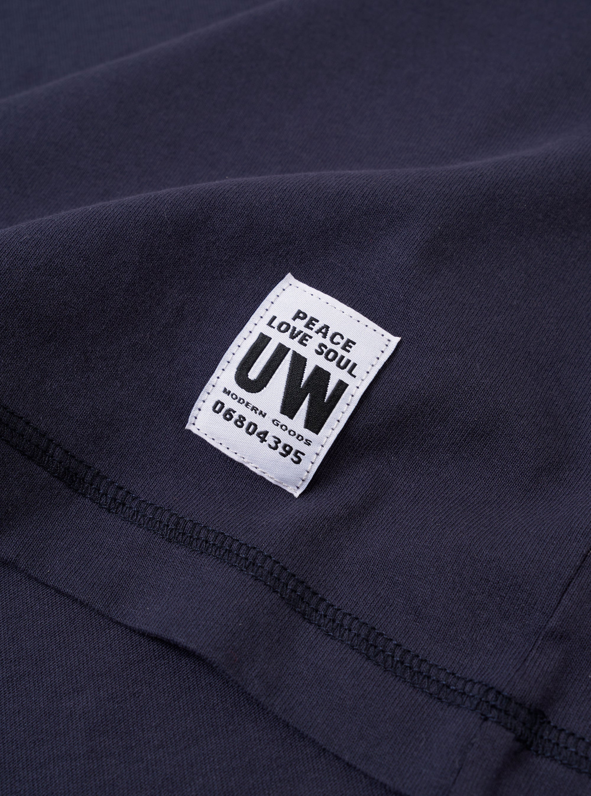 The Navy Recycled/Bio Jersey Core Pocket Tee is shown from the back as a flat lay against a plain white background. The image highlights the smooth texture of the navy blue jersey fabric, the short sleeves, and the ribbed crew neckline.