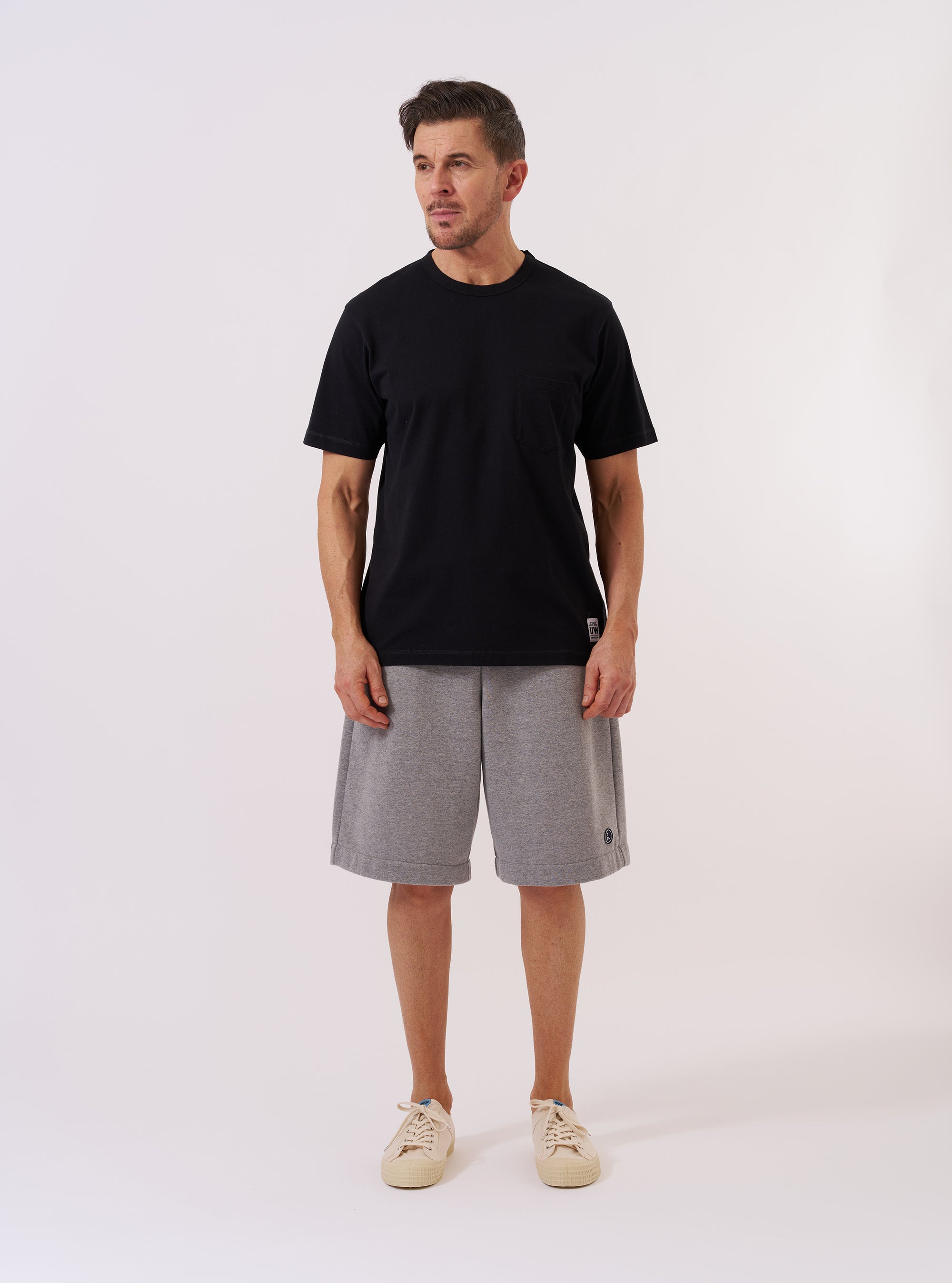 The Black Recycled/Bio Jersey Core Pocket Tee is shown as a flat lay against a plain white background. The T-shirt features a crew neck, short sleeves, and a single patch pocket on the left chest. The black fabric is a smooth jersey with a matte finish.