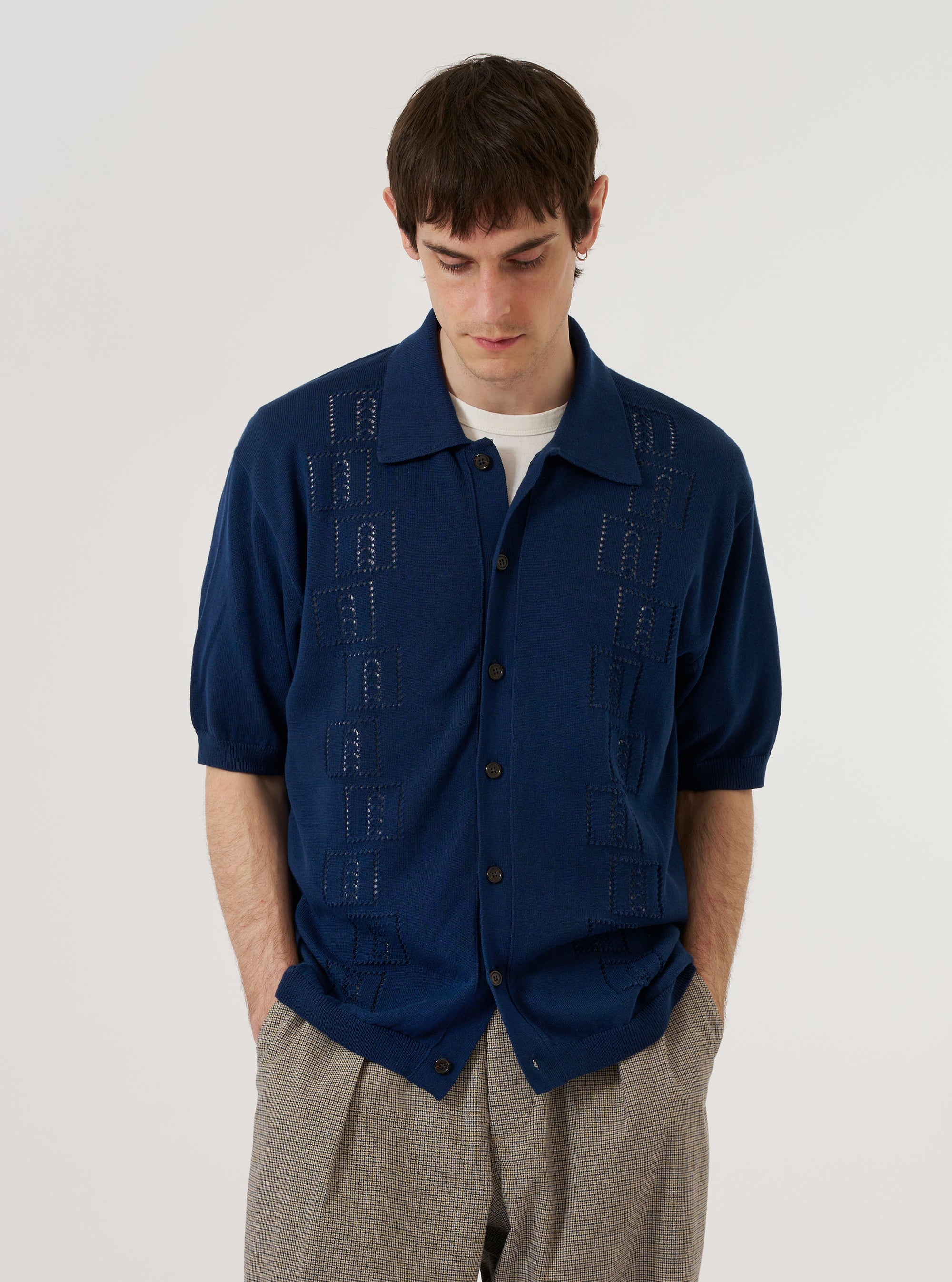 A model wears the Dark Navy Cotton Lace Knit Jonny Knit Shirt against a plain white background. The shirt features a classic collar, a short-sleeved design, and a front button placket. The dark navy fabric has an intricate lace knit texture with visible open-work perforations throughout. No mannequin is present in the image.