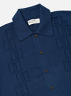 The Dark Navy Cotton Lace Knit Jonny Knit Shirt is shown as a flat lay against a plain white background. The shirt features a short-sleeved, boxy silhouette with a flat split collar and a straight hem. The dark navy cotton fabric is characterized by an intricate, open-textured square lace knit pattern throughout.